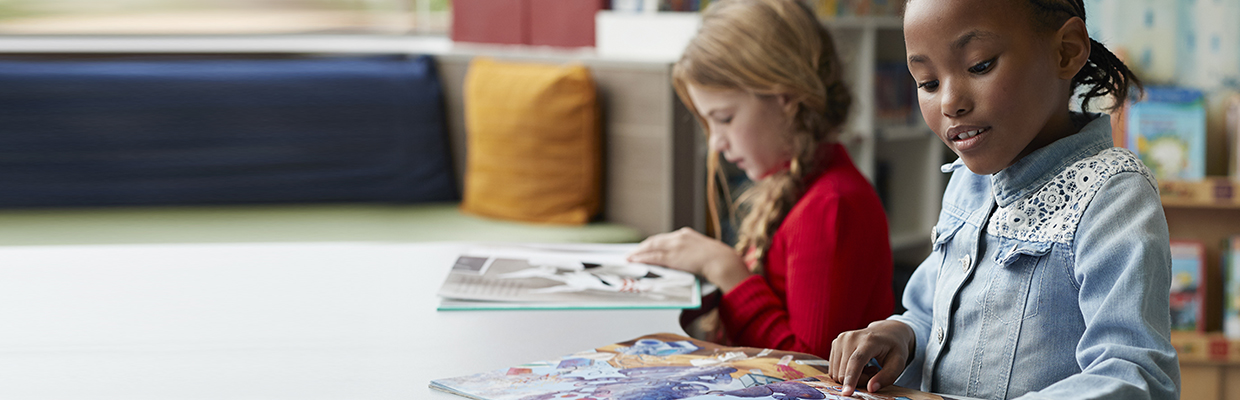 schoolgirls reading books in school library; image used for HSBC Sri Lanka Dining Household and Stationary Merchant Partners Landing Page