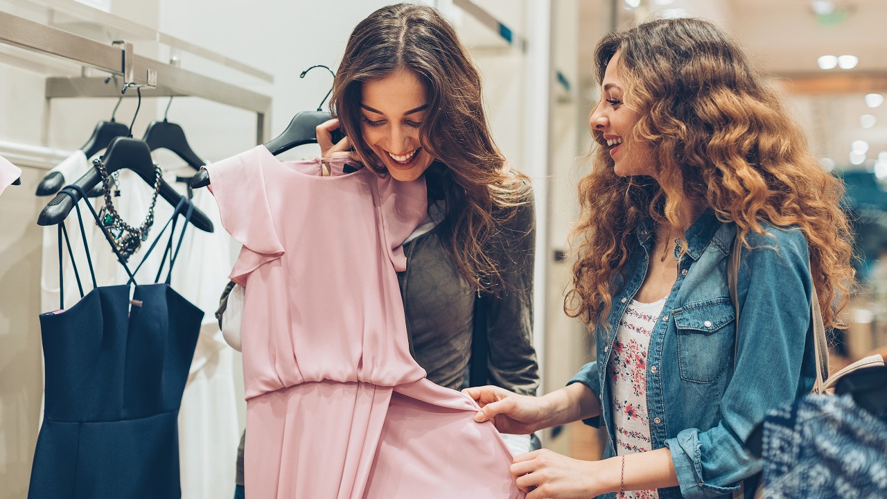 two young women happily picking up dresses; image used for HSBC Sri Lanka credit card shopping offer page